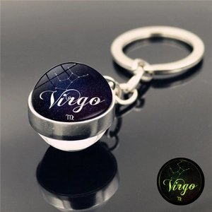 Detailed macro view of Virgo constellation luminous glass ball keychain with silver metal base