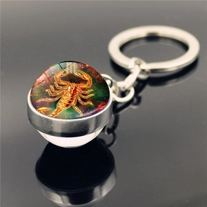 Macro detail of Scorpio zodiac keychain with double-sided glass ball and nebula pattern