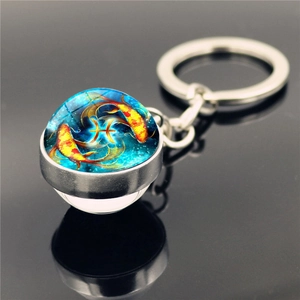 Macro view of double-sided Pisces zodiac glass ball keychain with silver metal base