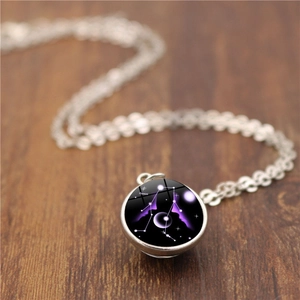 Vue macro du pendentif globe en verre double face avec constellation Gémeaux