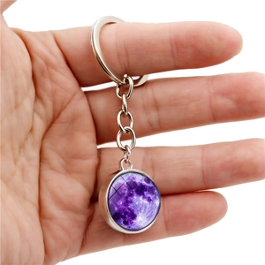 Porte-clés boule de verre lune lumineuse violette avec chaîne en métal argenté sur blanc