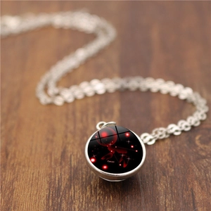 Détail macro du pendentif Cancer en verre argenté sur une surface en bois rétro