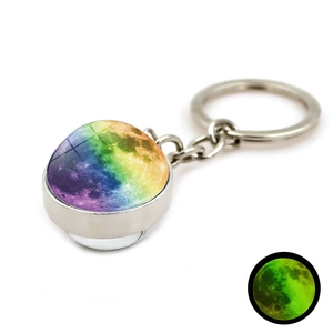 Gros plan du pendentif lune lumineuse avec porte-clés argenté montrant l'effet de nuit