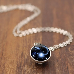 Détail macro du pendentif zodiaque Capricorne avec globe en verre sur chaîne argentée