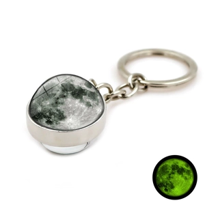 Détail du porte-clés cabochon en verre lune avec effet fluorescent vert dans le noir