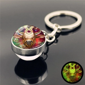 Detailed close-up of luminous Taurus zodiac glass ball keychain with starry nebula effect