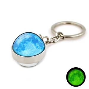 Détail d'un porte-clés lune luminescente avec effet brillant dans la boule en verre