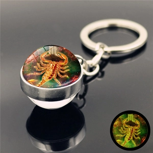 Detail view of Scorpio zodiac luminous crystal glass ball keychain with glowing green effect