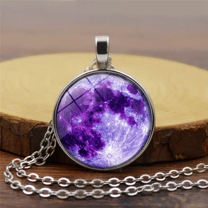 Primer plano detallado del colgante de luna púrpura con cadena de plata sobre madera