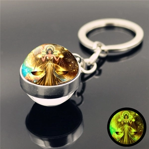 Detail showing Libra constellation keychain with glowing glass ball and silver ring