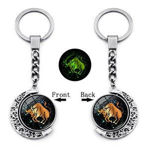 Luminous Taurus zodiac keychain with double-sided rotating moon pendant in dark green glow