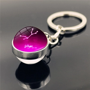 Macro shot of Virgo zodiac glass ball pendant with purple nebula design on metal keychain