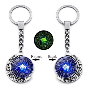 Luminous Taurus zodiac keychain with rotating moon pendant showing front and back views