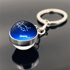 Detailed view of Gemini constellation glass ball pendant with silver metal keychain