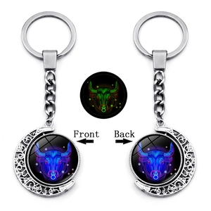 Glow-in-the-dark Taurus zodiac moon keychain with rotating double-sided neon design