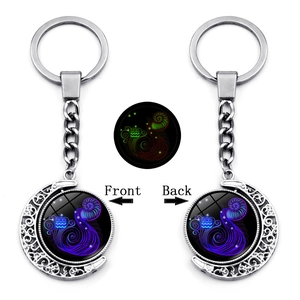 Detailed macro view showing the front and back of the luminous Aquarius zodiac keychain