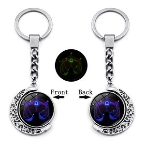 Detailed view of luminous Libra constellation spinning moon pendant on silver keychain