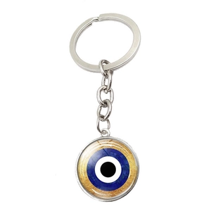 Detail showing the classic blue Evil Eye charm with textured gold finish on metal keychain