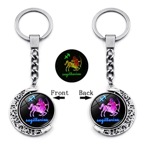 Detail of a rotating Sagittarius keychain with a luminous moon pendant and metal finish