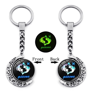 Luminous Pisces zodiac keychain with double-sided rotating moon pendant and green glow detail