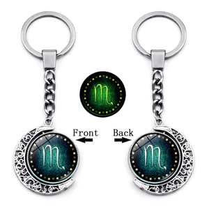 Close-up of Scorpio rotating moon keychain with green luminous zodiac sign effect