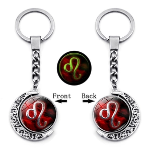 Glow in the dark Leo zodiac keychain with silver moon pendant and red nebula rotating charm