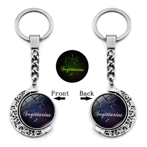 Detailed view of Sagittarius luminous keychain with rotating moon pendant and glow feature