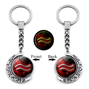 Detailed view of Aquarius glowing keychain with silver moon frame and red nebula glass