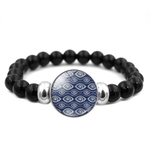 Dettaglio del bracciale con perline nere, ciondolo Evil Eye blu e distanziatori argentati