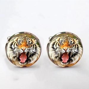Detailed close-up of round silver cufflinks featuring a lifelike tiger head pattern