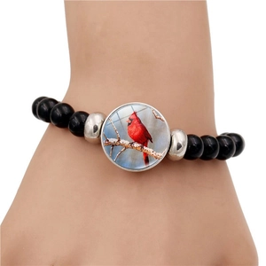 Beaded cardinal bird bracelet featuring black stones and round winter bird glass charm