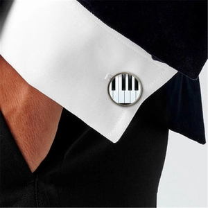 Boutons de manchette ronds piano sur une manche de chemise blanche sous une veste noire