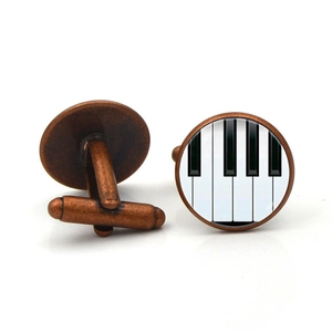 Détail des boutons de manchette piano avec finition bronze vintage et dôme en verre poli