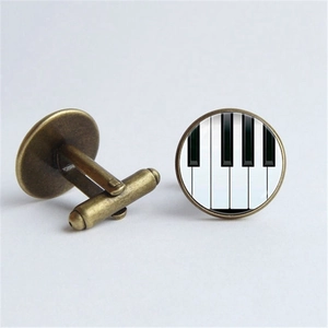 Détail de boutons de manchette motif piano en métal bronzé avec fermeture en T