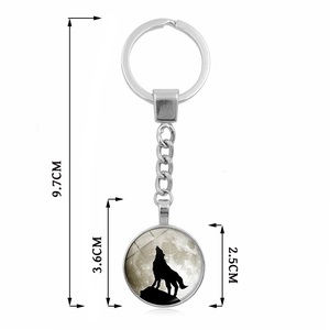 Luminous howling wolf keychain featuring a glass cabochon pendant on a metal ring chain