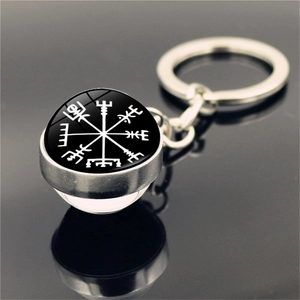 Macro side view of silver metal Viking Vegvisir compass keychain with glass dome pendant