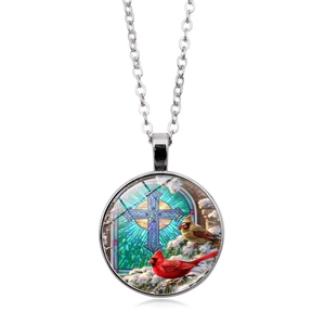 Detail of cardinal bird stained glass pendant with cross and silver chain necklace