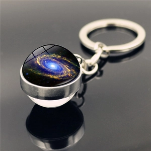 Détail macro du porte-clés galaxie en verre avec anneau argenté et motif nébuleuse spirale