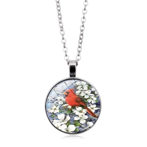 Macro detail of cardinal bird pendant featuring vivid red bird and white flower patterns
