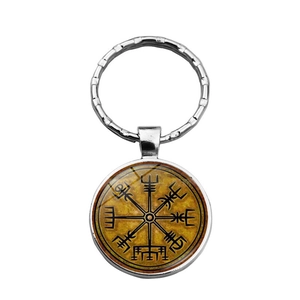 Macro view of Viking Vegvisir compass pendant with metallic keyring on white background