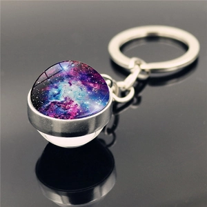 Détail macro du porte-clés galaxie en verre avec pendentif nébuleuse et reflet noir