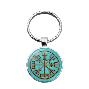 Silver Viking Vegvisir compass keychain with blue background and glass dome on white backdrop