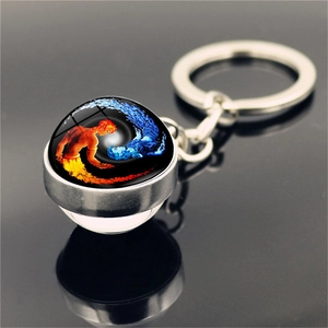 Macro view of yin yang fire and ice artistic glass ball pendant on silver metal keychain