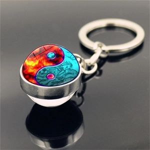 Macro shot of Yin Yang keychain with red and blue fire-water glass dome and metal ring