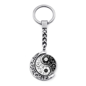 Detail showing the rotating Yin Yang pendant with intricate moon frame and swirl engraving