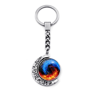 Macro view of rotating moon pendant with blue and red spiral yin yang design keychain
