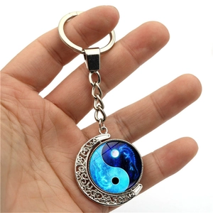 Rotating Yin Yang Dragon moon keychain with silver hollowed-out engraving and blue glass pendant
