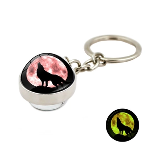Porte-clés lumineux avec silhouette de loup et dôme en verre brillant dans le noir