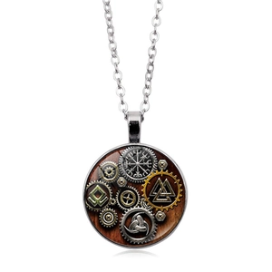 Detail of Viking compass and steampunk gears under glass dome on silver pendant