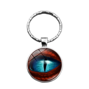 Gros plan d'un pendentif en verre œil de dragon bleu sur un porte-clés argenté